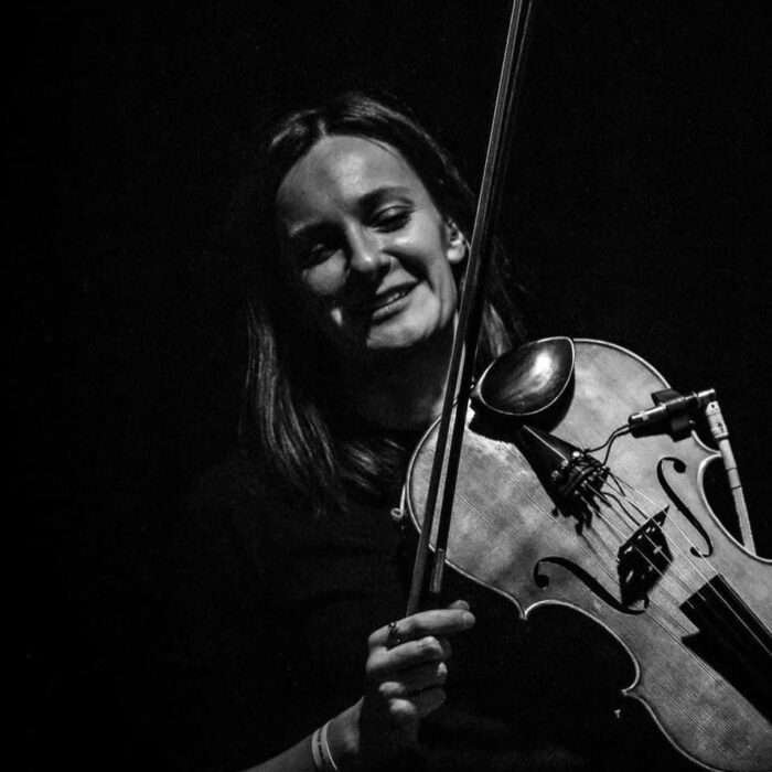 czarno-białe zdjęcie kobiety grającej na skrzypcach