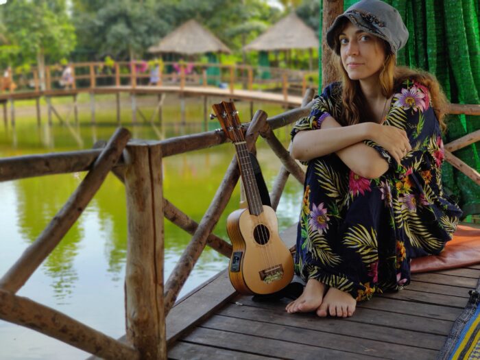 kolorowe zdjęcie artystki - kobieta siedząca na moście z instrumentem ukulele - Ranko Ukulele