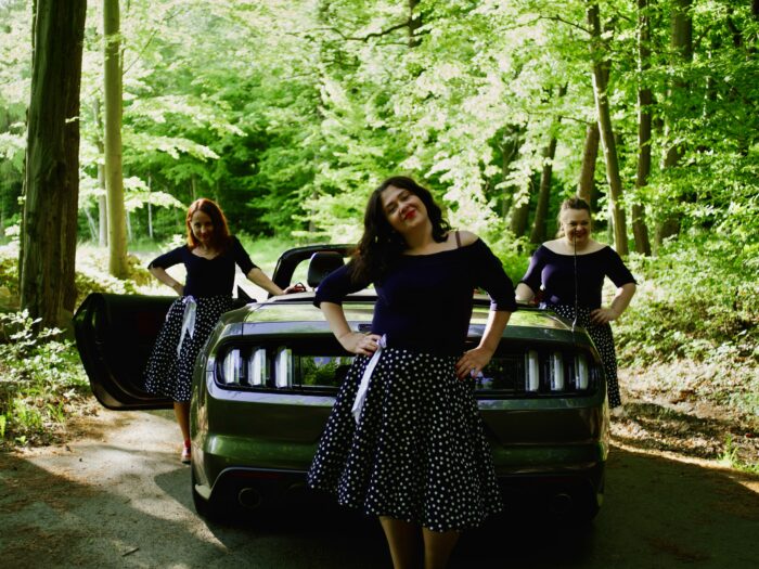 kolorowe zdjęcie trzech kobiet przy samochodzie na tle zielonych drzew - zespół Kropki3